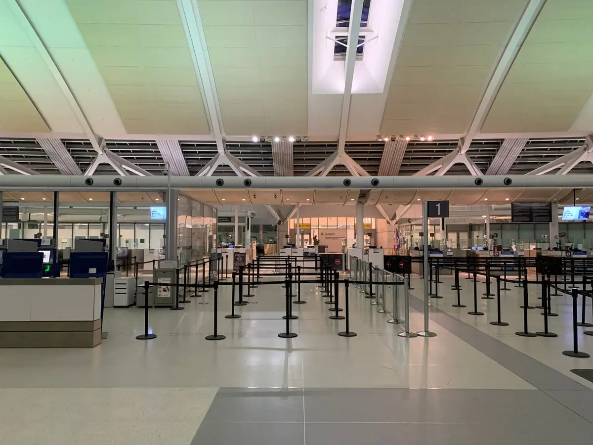 An airport check-in hall with the queue barriers empty