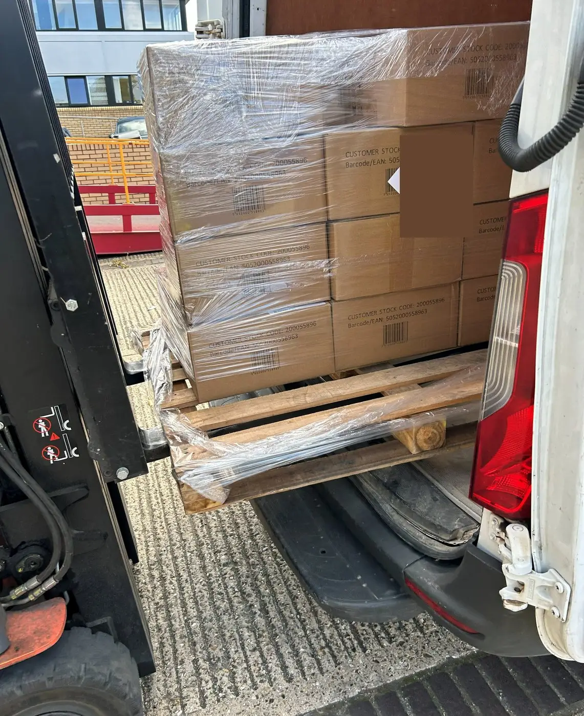 A pallet being loaded into a van at a loading bay