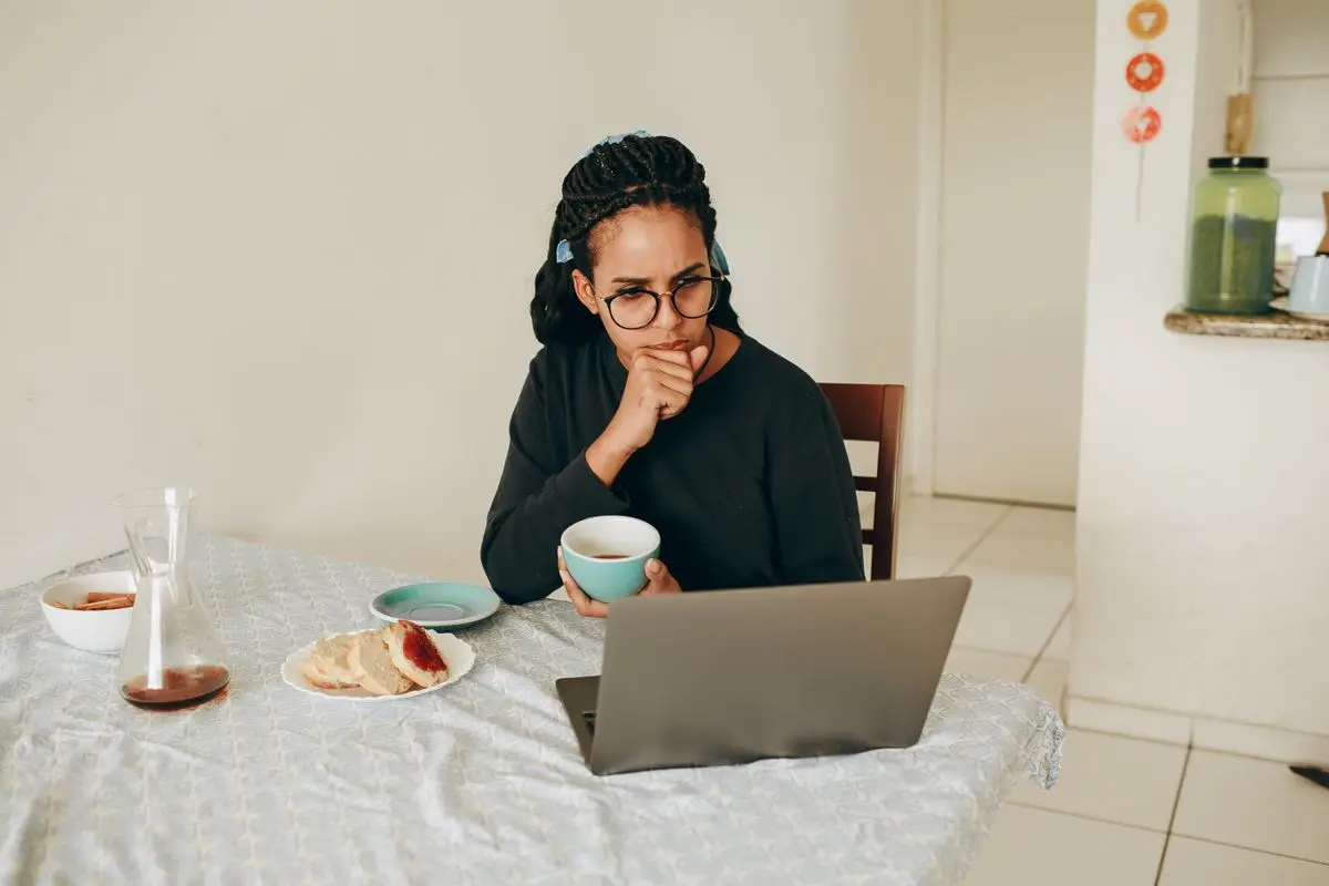 A woman working on a laptop at a table