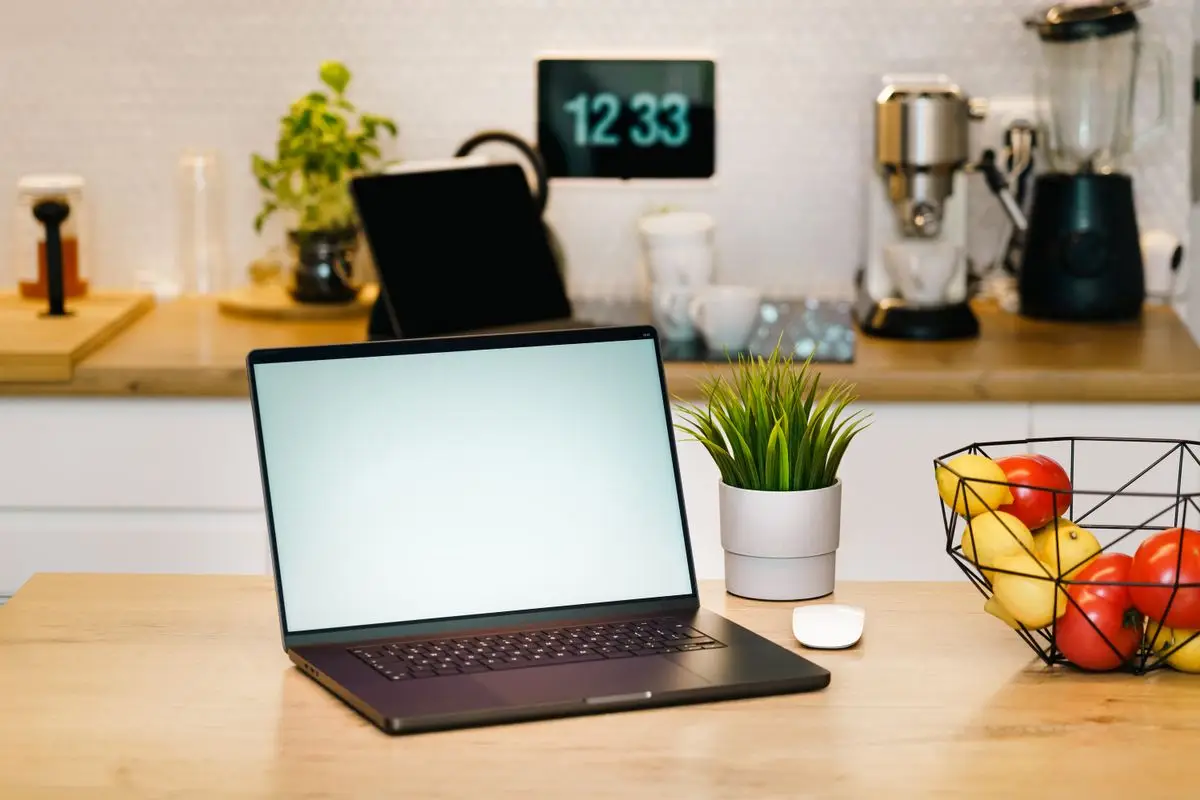 A laptop open on a kitchen counter