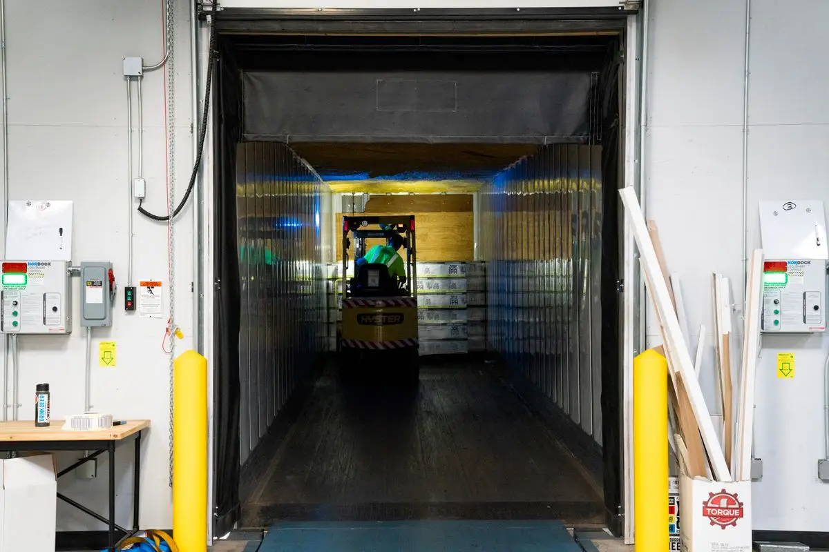 A loading dock with a forklift inside a trailer