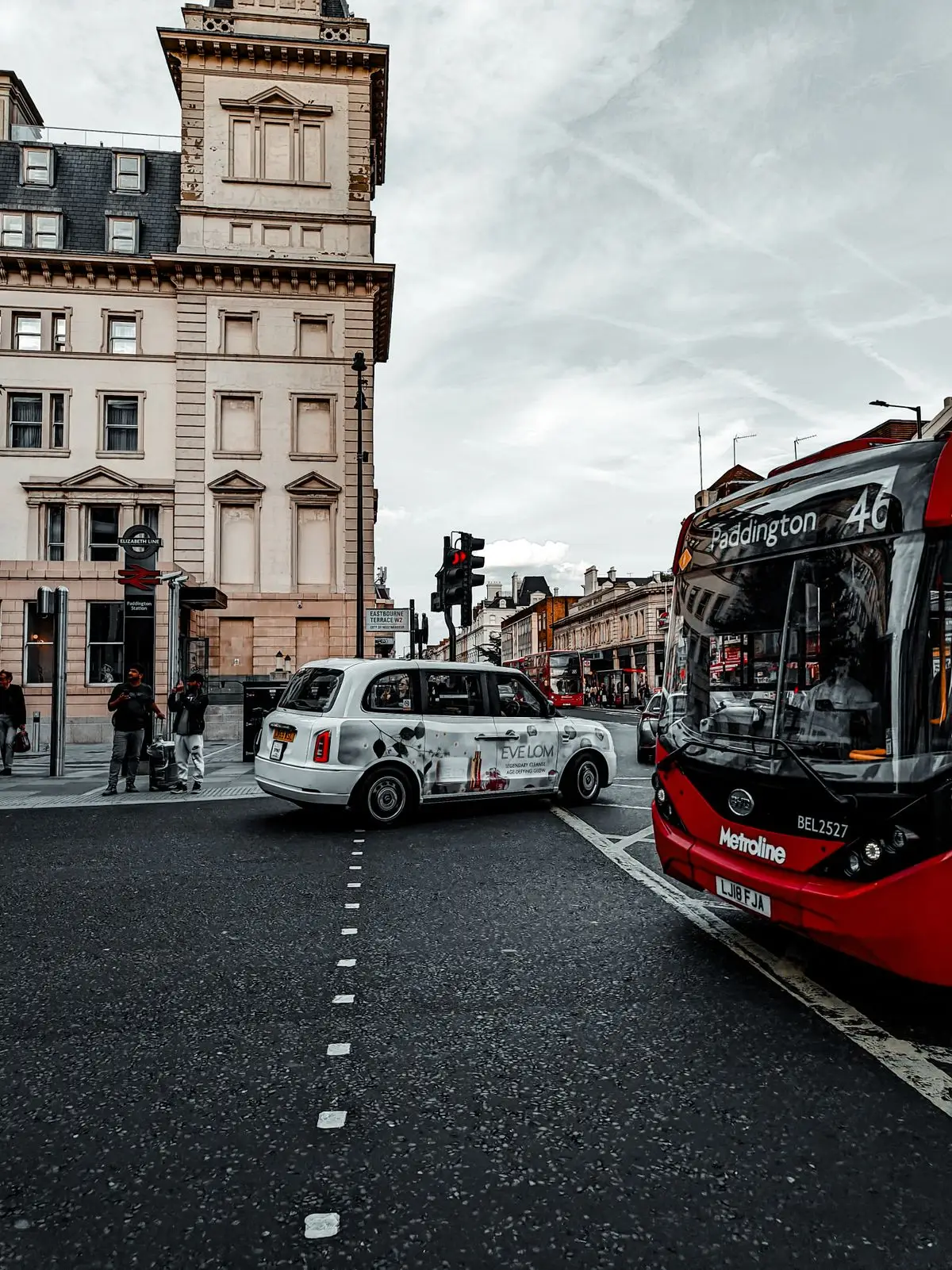 A bus and a black taxi at a London intersection