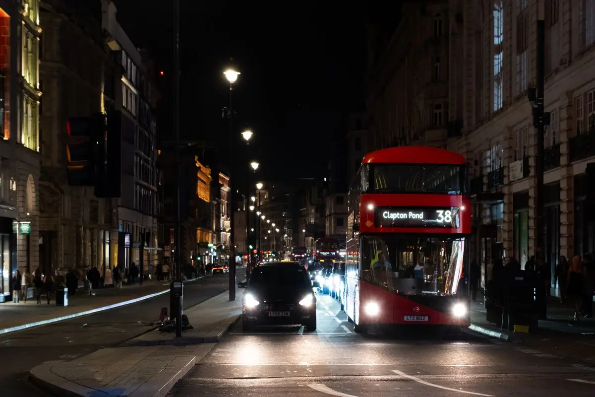 A London street at night with a red bus