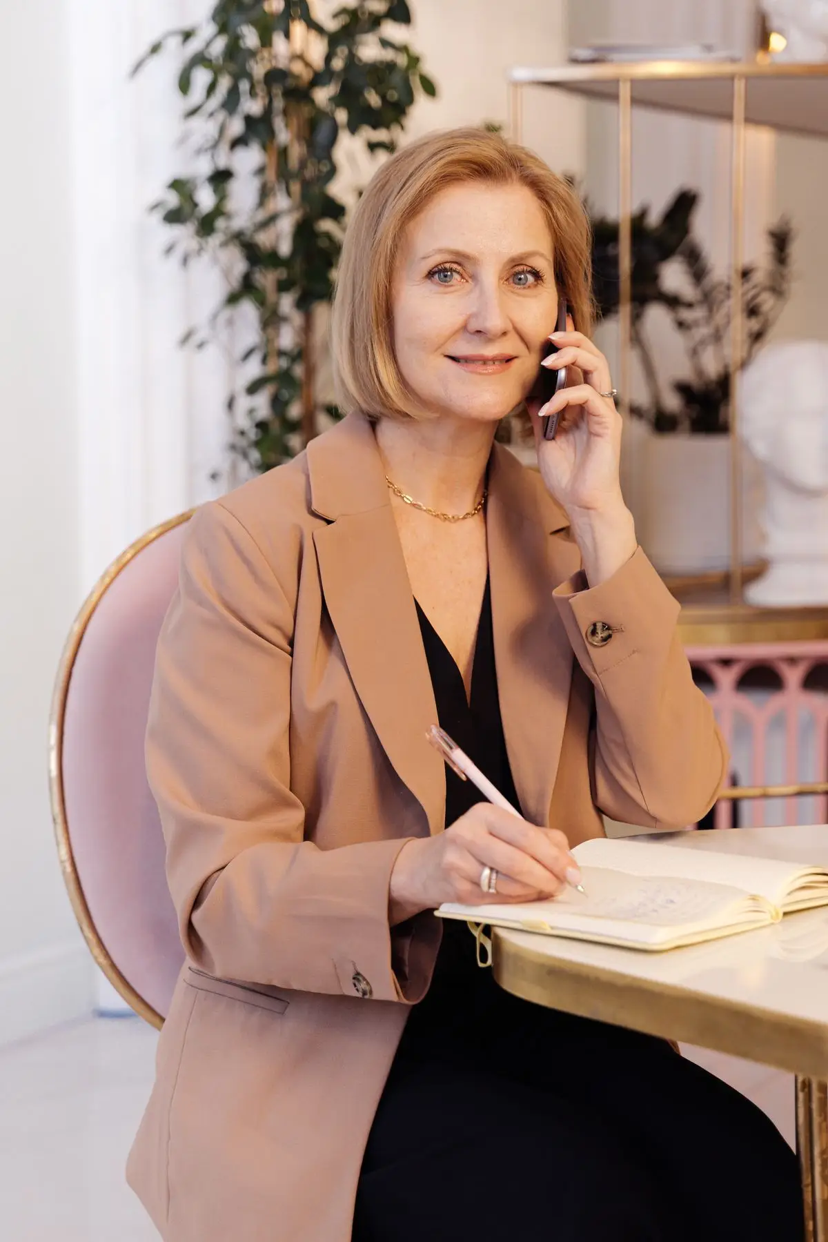 A woman on the phone writing notes